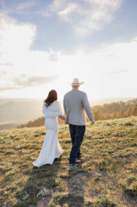 couple walking into the mountain sunset. photo captured by Michelle Betz Photography