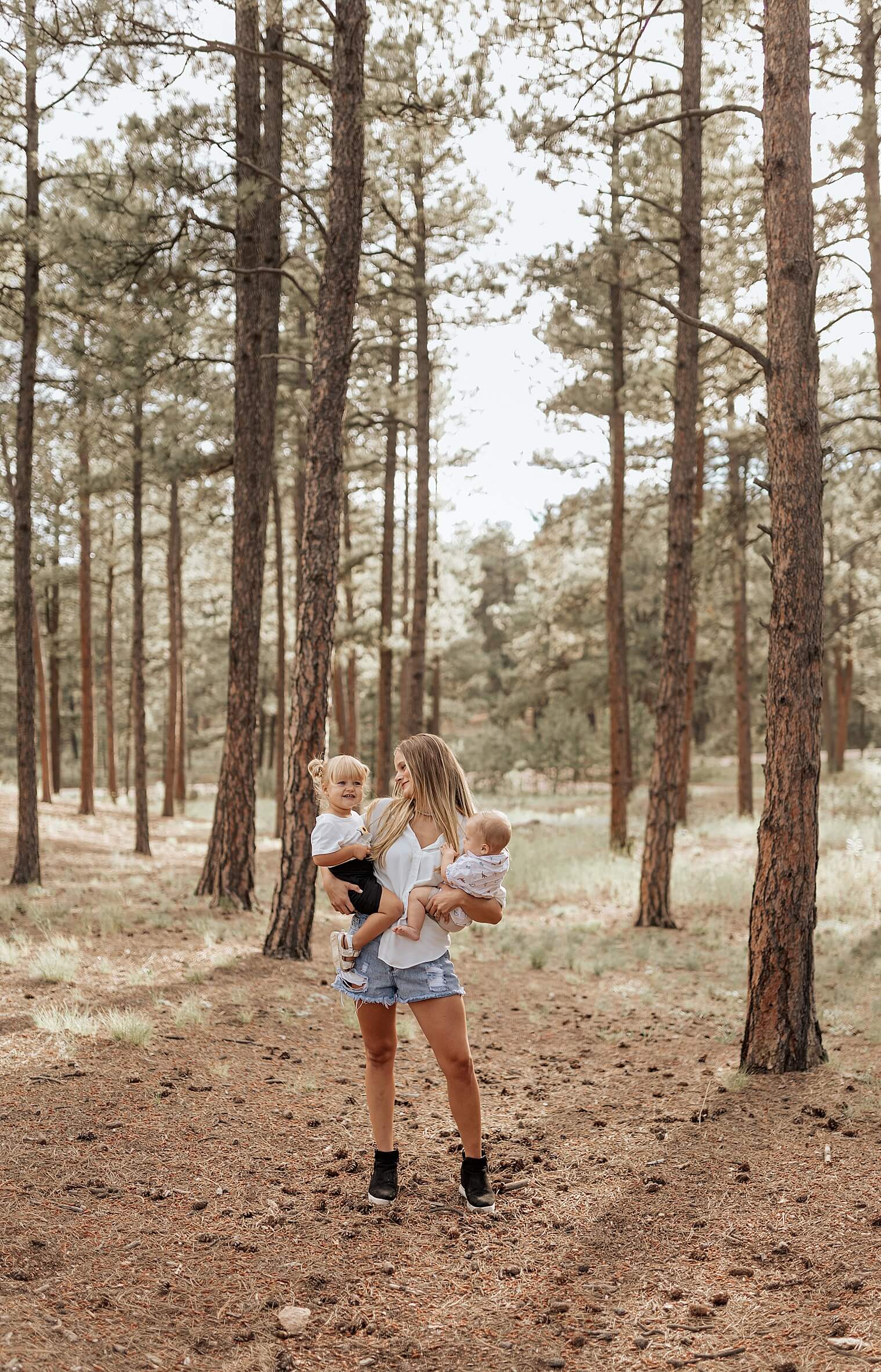 mom looking and smiling holding little kids