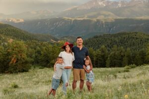 colorado family photoshoot. Surrounded by beautiful green grass and mountains.