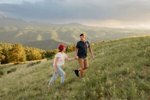 Colorado couple holding hands and walking. Surrounded by Denver mountains.