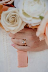 A wedding detail photo of the brides hand holding her bouquet. Photo captured by Michelle, a Colorado wedding photographer.