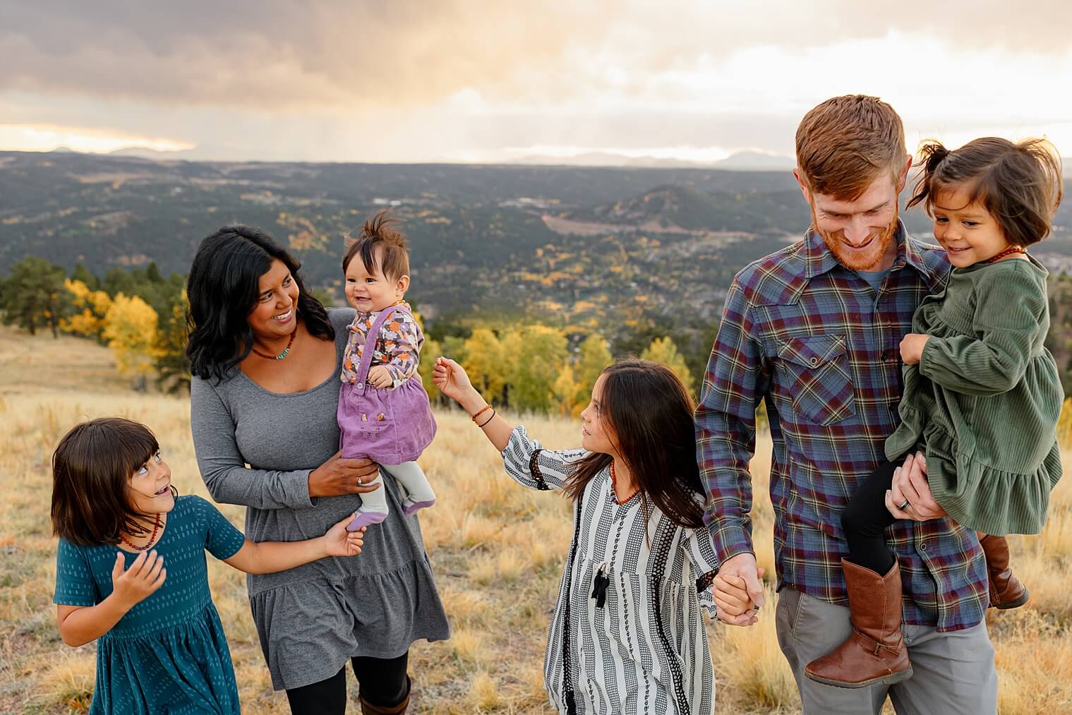 A family walking together on top of a mountain in Colorado Springs. Captured by Michelle, a family photographer.