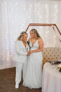 A couple standing together for their formal prayer at their wedding reception. Captured by Colorado Springs wedding photographer.