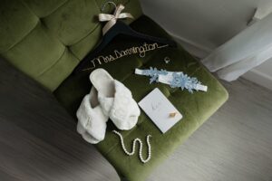 A detail shot of the brides details on on a green chair. Captured at a Aurora wedding venue.