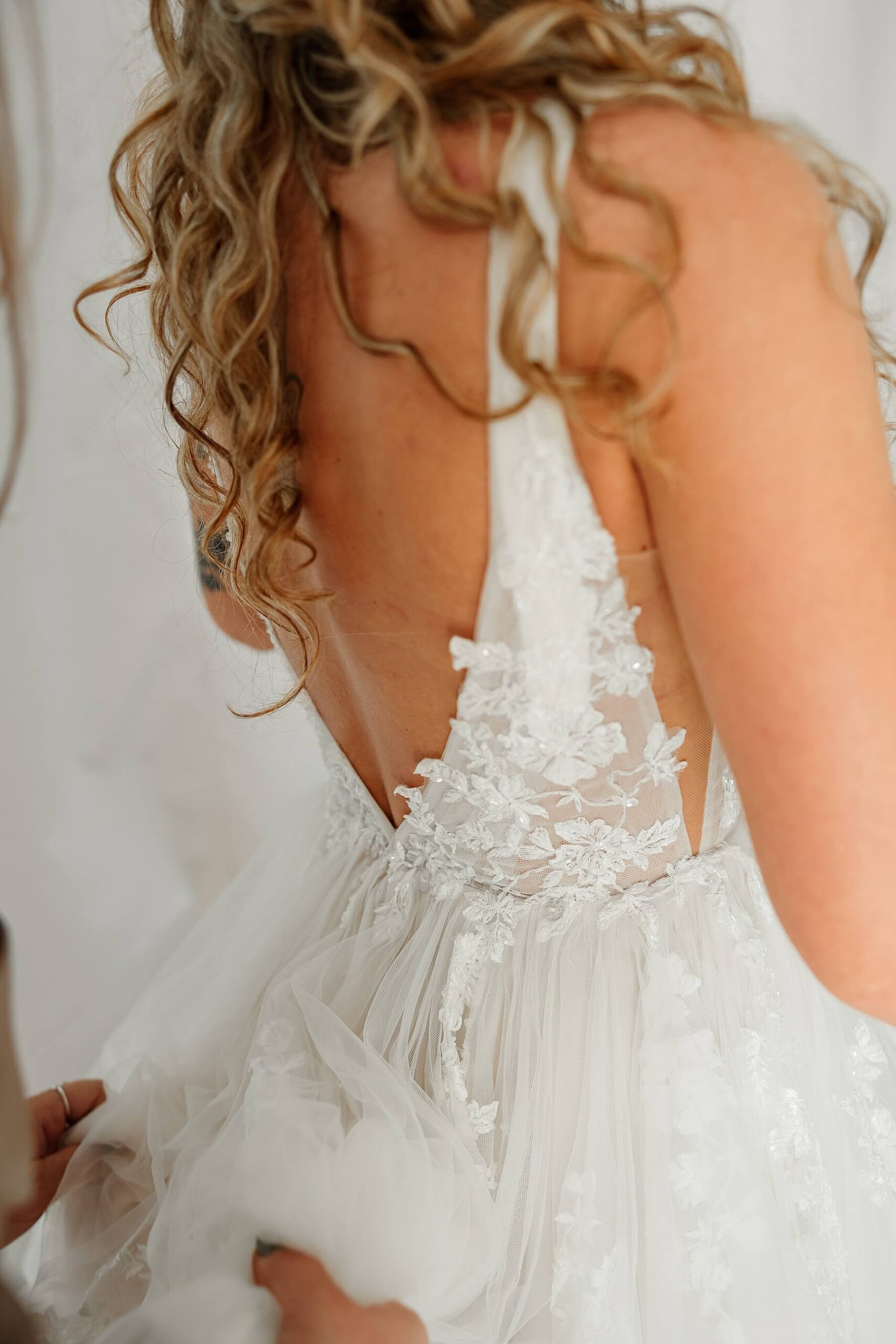 A detail shot of the bride getting her wedding dress fluffed. Captured by Michelle Betz Photography, a Colorado wedding photographer.