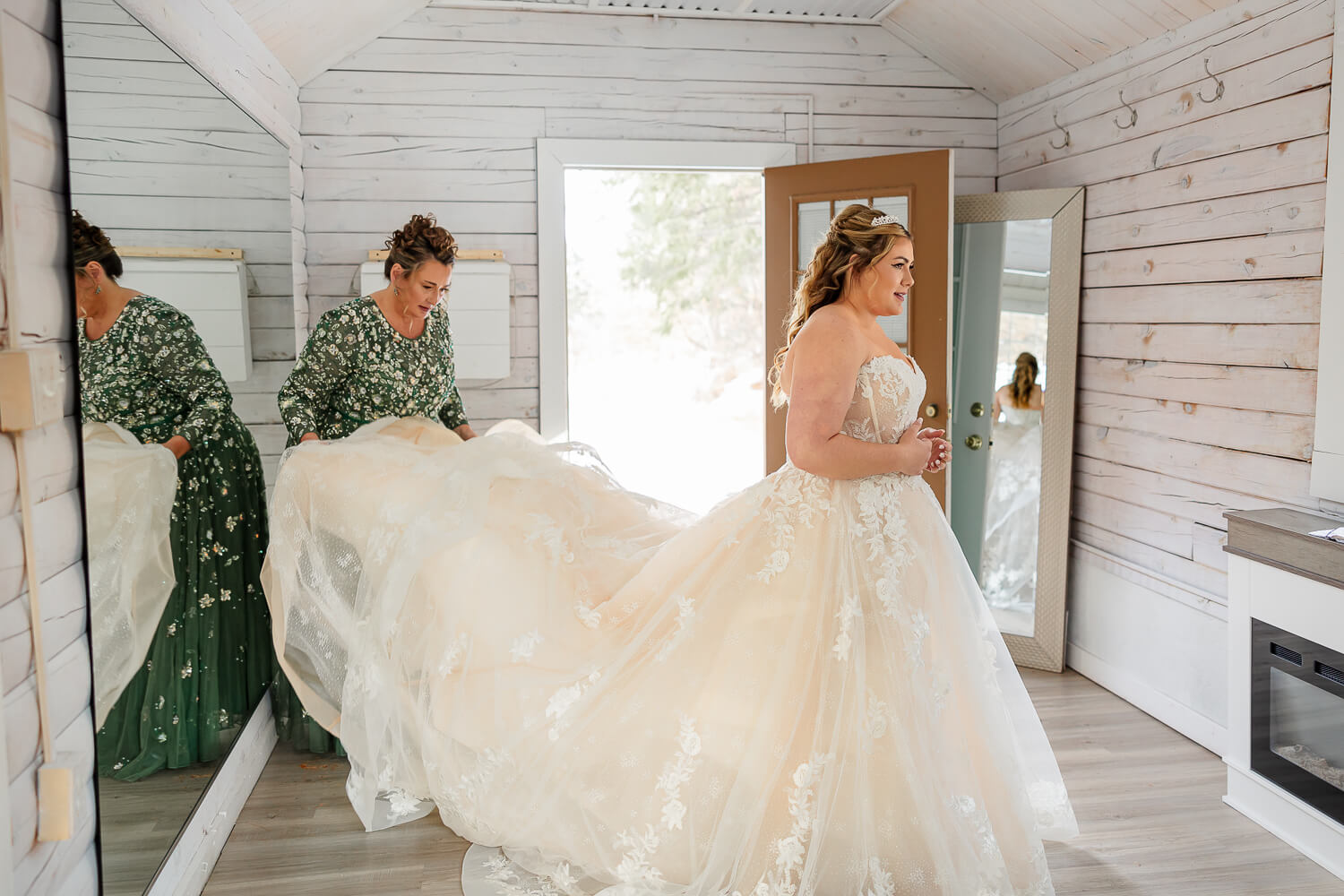 bride getting her wedding dress fluffed by her mother at a Colorado wedding venue