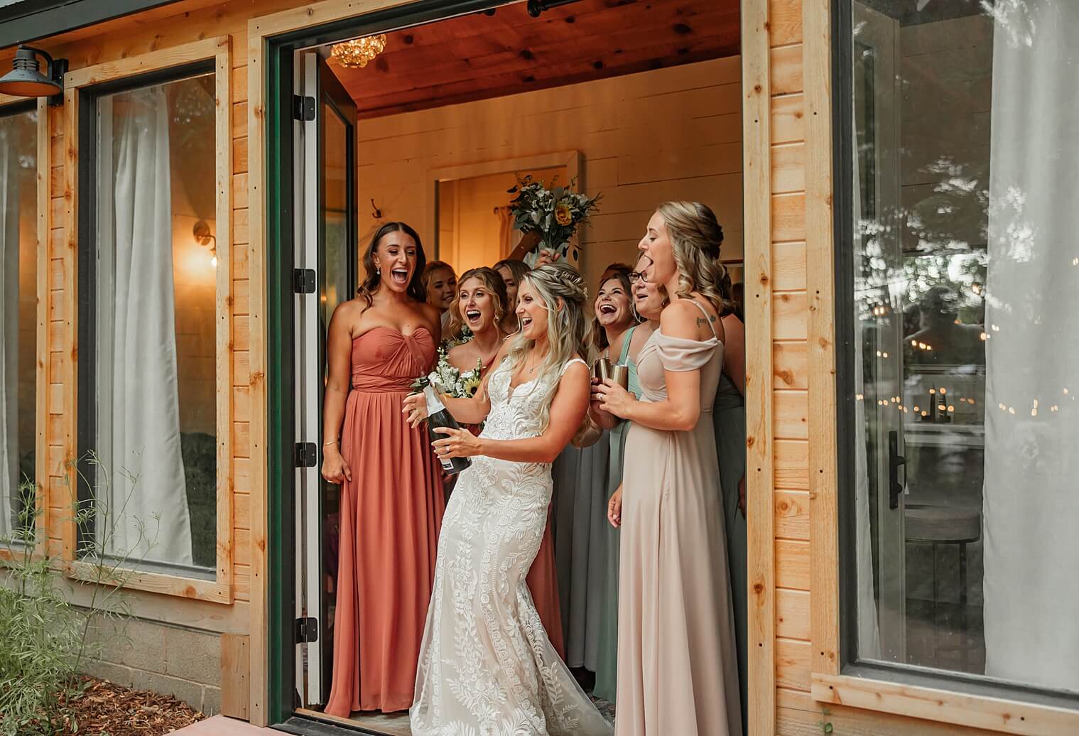 bride and bridesmaids popping champagne. captured by Michelle Betz photography