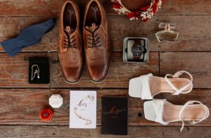 details at the best colorado wedding venue of shoes, invitation, rings, vows - on a wooden floor