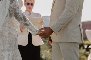 Bride and groom at the alter getting married. A close up photo of them holding hands. Captured by Colorado Elopement Photographer, Michelle Betz Photography