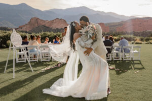 A bride and groom kissing after they got married and walked back down the isle. Surrounded by the red rocks of Garden of the gods resort