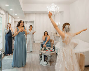 A bride revealing her in the wedding dress to her bridesmaids. Captured by Michelle, at a Estes Park wedding venue.