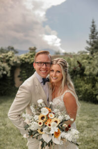 A bride and groom portrait. The couple is in bridal attire and the bride has her bouquet. 