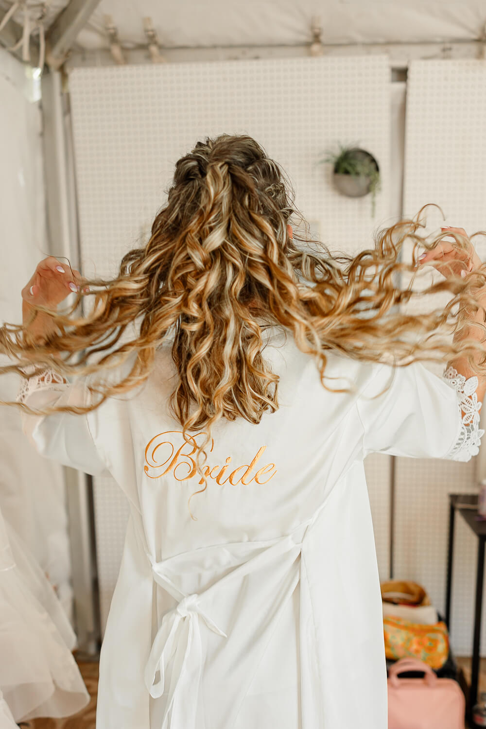 A bride with her white bride robe, flipping her hair back. Captured by Wedding & Elopement photographer, Michelle