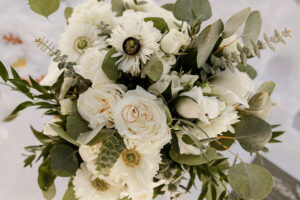 A detail photo of wedding bouquet with rings on flower peddles. 