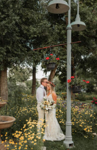 A bride and groom portrait. In wedding attire, surrounded by greenery and flowers. Captured by Colorado Springs wedding photographer, Michelle Betz