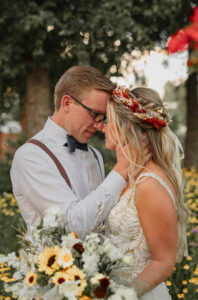 A groom holding his brides face, with their forheads touching. Photo taken at a brighton Colorado wedding venue.