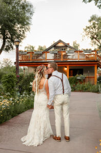 A bride and groom portrait. In wedding attire, kissing. 