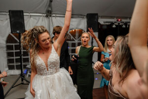 A bride dancing at her reception and having fun with her friends. Captured by wedding photographer Michelle Betz