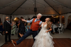 A reception photo of the bride dancing and having fun with her father. At a Colorado wedding venue.