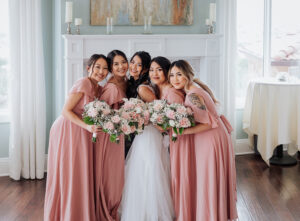 Bride and bridesmaids smiling together on the brides wedding day. In Estes Park, CO.