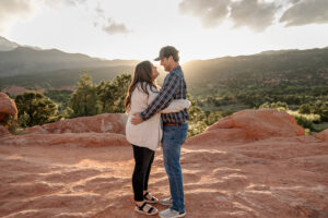 A couple hugging each other and looking into each others eyes. For their Denver engagement photoshoot. Surrounded by Garden of the Gods.