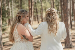 A bride and groom having an intimate moment as they have their first look before the wedding ceremony. Surrounded by forest trees. Captured by Michelle Betz Photography