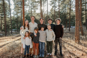 Extended family of all the grandchildren smiling together. Surrounded by forest and glowing sun.